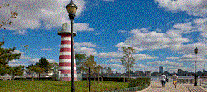 Jersey City apartment for rent - people walking by the lighthouse on the water in a park
